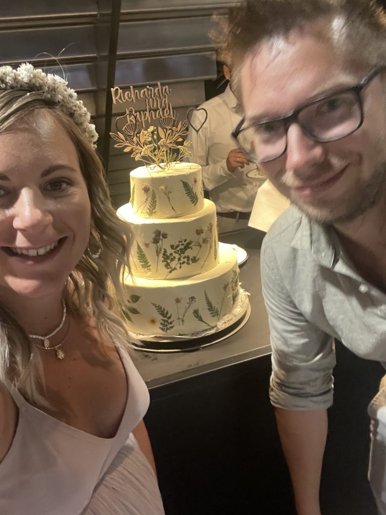 Mache/macht ein Foto mit der Hochzeitstorte.