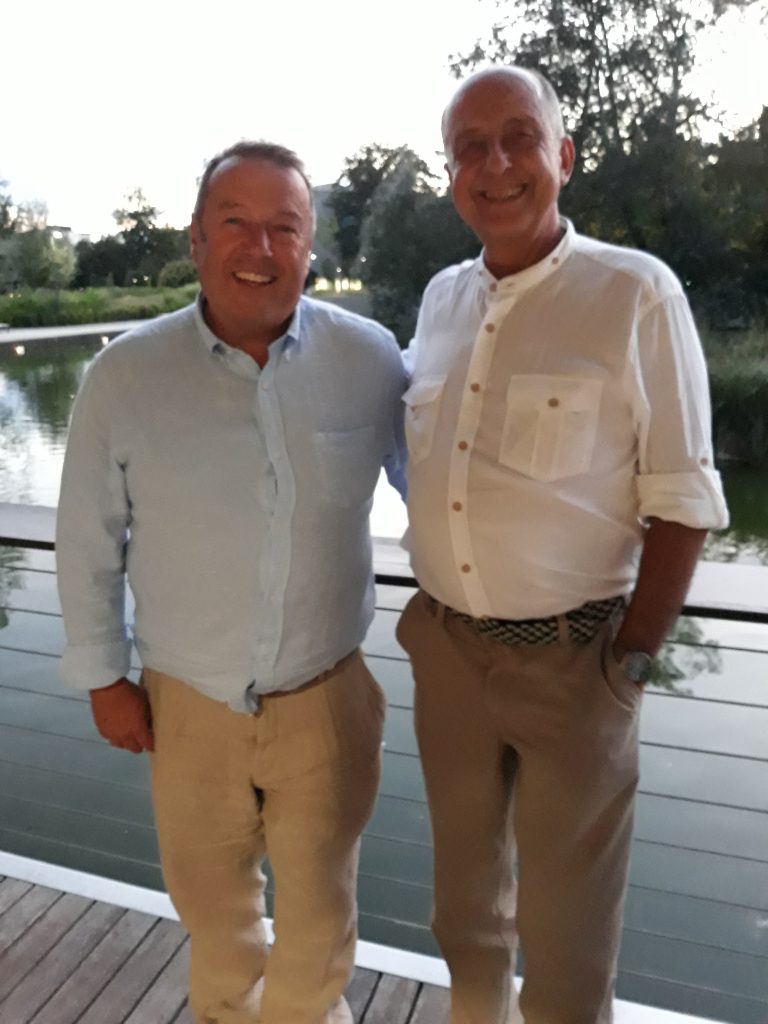 Mache/macht ein Foto mit dem Vater des Bräutigams.