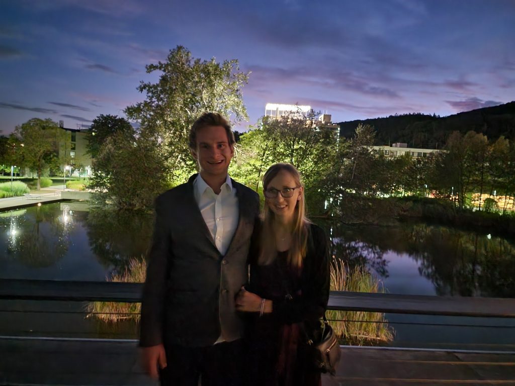 Mache/macht ein Foto mit dem Teich im Hintergrund.