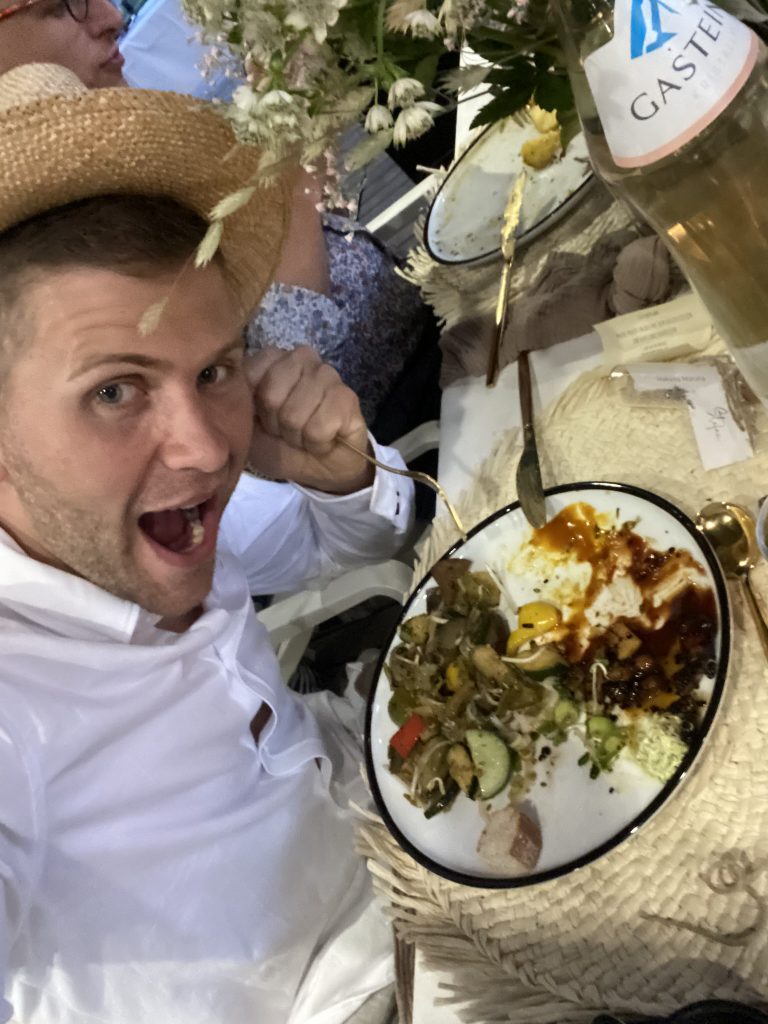 Mache/macht ein Bild mit dem Hochzeitsessen und guck dabei verfressen.