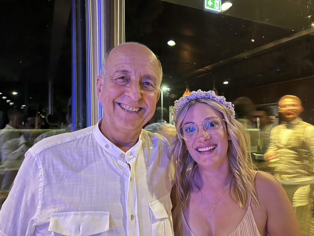 Mache/macht ein Foto mit dem Vater der Braut.