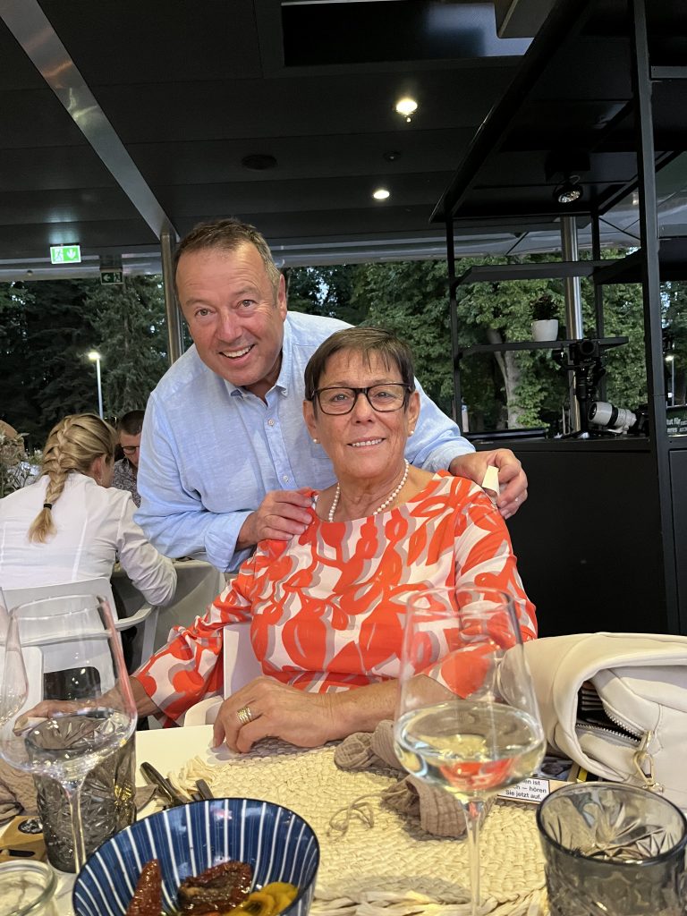Mache/macht ein Foto mit einem Gast, der eine Brille trägt.